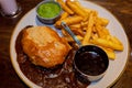 Traditional steak and ale pie and a pint in a Scottish pub with chips, gravy and mushy peas Royalty Free Stock Photo