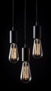 Edison bulbs hang and cast a warm glow in a dark, textured setting, perfect for creating a minimalist and inspiring environment. Royalty Free Stock Photo