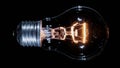 Edison lamp light bulb blinking over black, macro view