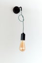 Edison retro lamp. Incandescent bulb on white wall background in loft. Concept of vintage style Royalty Free Stock Photo
