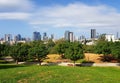 Edith Wolfson Park. Alley, wooden benches and green trees. Distance view from grassy park hill on Tel Aviv and Ramat Gan