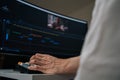 Editor working on professional video editing software, using computer workstation with wide monitor showing timeline and Royalty Free Stock Photo
