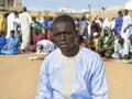 Street prayer, a Friday in Senegal. Unidentified young Muslim man praying in the street, celebration clothing