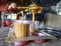 EDITORIAL DATED :19th february 2020 LOCATION :dehradun uttarakhand India. A tea seller in rural India pouring tea into a glass,