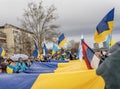 Editorial image, February 25, 2023, Novi Sad, Serbia. A crowd of people holding a large national Ukrainian flag at a