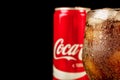 Editorial photo of Close-up Coca-Cola glass with ice and can on wooden table and copy space on black. Horizontal photo Royalty Free Stock Photo