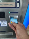 Editorial photo, indonesia, east jakarta, 10th october 2022, close up man hand make at financial transaction at ATM BCA Royalty Free Stock Photo