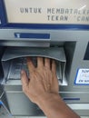 Editorial photo, indonesia, east jakarta, 10th october 2022, close up man hand make at financial transaction at ATM BCA Royalty Free Stock Photo