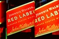 Editorial selective focus photo of Johnnie Walker Red Label Scotch whisky bottles - a brand of Scotch whisky