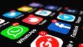 Editorial shot: icons of social media apps with numbers on notification counter on black screen smartphone. Mobile app