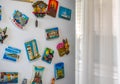 Editorial souvenir magnets photo. Country and famous city magnets on fridge surface in the kitchen. Royalty Free Stock Photo