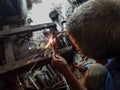 Blurred An old welder in a blue T-shirt use sunglasses.