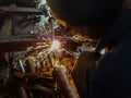 An old welder in a blue T-shirt use sunglasses. Selective focus on firework.