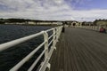 Editorial, Wide angle of pier and with hand rail in foreground , RNLI Lifeboat station and seafront houses, Beaumaris, United