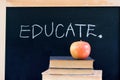 EDUCATE on chalkboard with apple & books Royalty Free Stock Photo