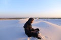 Educated Arab student uses laptop and works sitting on sand amid