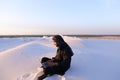 Educated Arab student uses laptop and works sitting on sand amid