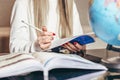 Student girl sits at a table with notebooks, books holds a pencil in her hands and learns English, does her homework Royalty Free Stock Photo