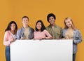 Diverse teens cheerful international students holding big banner with free space and ready to study