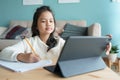 Education. Asian little girl is learning with online tutor via the internet on tablet digital at home morning. Asia children watch Royalty Free Stock Photo