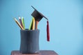 Education and back to school concept with graduation cap pencils color in a pencil case on blue background Royalty Free Stock Photo