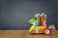 Education and back to school concept. pencils stand as bus over wooden desk infront of classroom blackboard Royalty Free Stock Photo