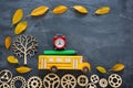 Education and back to school concept. Top view photo of cardboard school bus, alarm clock and pencil next to tree with autumn dry Royalty Free Stock Photo