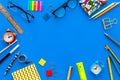 Education background, frame. School, student, office supplies. Stationery, glasses, alarm clock, notebook on blue Royalty Free Stock Photo