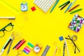 Education background, frame. School, student, office supplies. Stationery, glasses, alarm clock, notebook on yellow Royalty Free Stock Photo