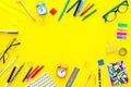 Education background, frame. School, student, office supplies. Stationery, glasses, alarm clock, notebook on yellow Royalty Free Stock Photo