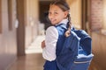 Education, backpack and learning with a school girl walking down a corridor to class to study for development. Children Royalty Free Stock Photo