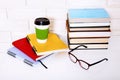 Education books literature and notebooks with accessories on workplace near brick wall. Top view and selective focus.