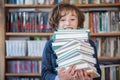 Schoolboy read books, Cute boy reading book in library Royalty Free Stock Photo