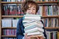 Schoolboy read books, Cute boy reading book in library Royalty Free Stock Photo