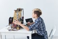 Education, children, technology concept - teen boy is printing on 3d printer.