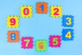 Colorful kids numbers toys on blue background. Place for design