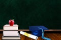 Education Concept With Graduation Hat, Diploma and Books on Blackboard Background Royalty Free Stock Photo