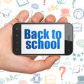Education concept: Hand Holding Smartphone with Back to School on display Royalty Free Stock Photo