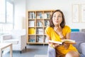 Happy student woman thinking and having interesting idea while reading book in library Royalty Free Stock Photo