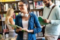 Education concept. University students preparing for exam, talking in library Royalty Free Stock Photo