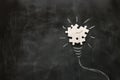 Education concept image. Creative idea and innovation. Puzzle as light bulb metaphor over blackboard Royalty Free Stock Photo