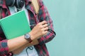 Education Concept. Man in Scottish shirt.Holding green notebook Waiting studying,learning ,Tutor books with friends.