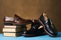 Education concept with mens leather shoes and stack of book
