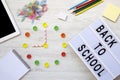 Education concept. Nine o`clock on watch. Clock made of colorful candies, `back to school` word on lightbox, accessories for st