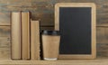 Education concept. Online education course. Books and disposable cup on wooden surface Royalty Free Stock Photo