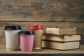 Education concept. Online education course. Books and disposable cup on wooden surface Royalty Free Stock Photo