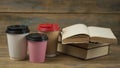 Education concept. Online education course. Books and disposable cup on wooden surface Royalty Free Stock Photo