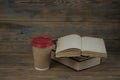 Education concept. Online education course. Books and disposable cup on wooden surface Royalty Free Stock Photo