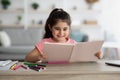 Education Concept. Portrait Of Cute Little Arab Girl Reading Book At Home Royalty Free Stock Photo