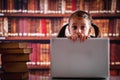 Education concept. Portrait of young beautiful child girl working  with laptop and reading books in library. Horizontal image Royalty Free Stock Photo